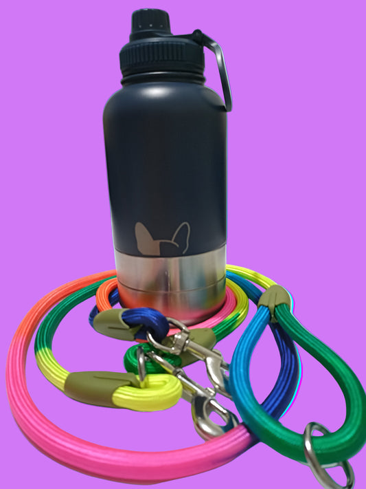 Black water bottle with colourful dog leash on a white surface