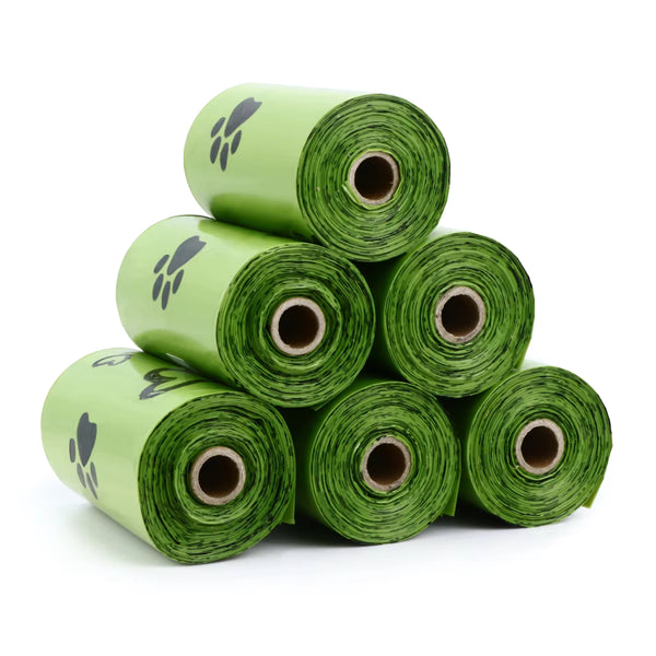 Stack of green rolls with paw print design on a white background